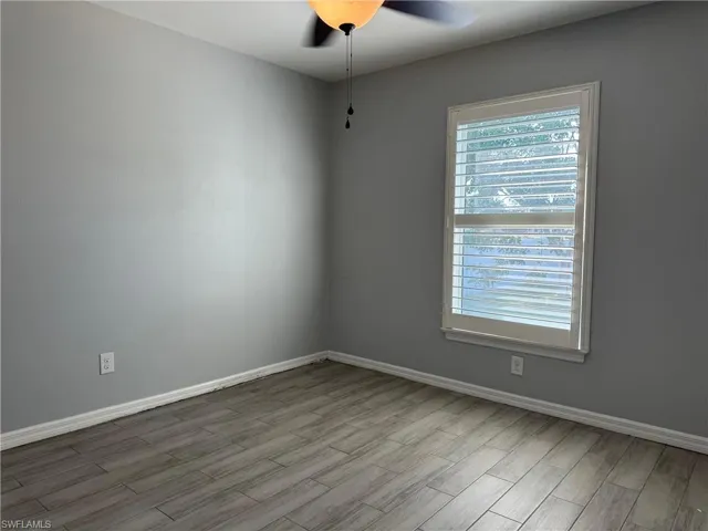 Empty room with wood finished floors and ceiling fan
