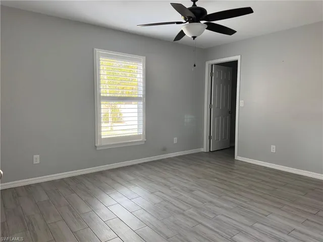 Empty room with wood tiled floors and ceiling fan