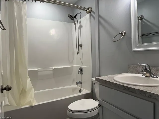 Bathroom with shower / bath combo with shower curtain and vanity