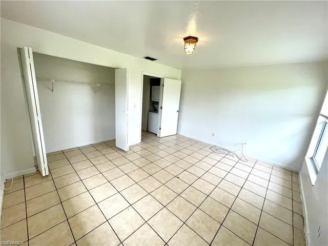 Unfurnished bedroom with a closet and washer / dryer