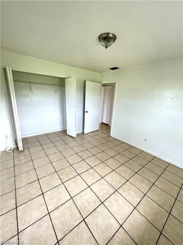 Unfurnished bedroom featuring a closet and baseboards
