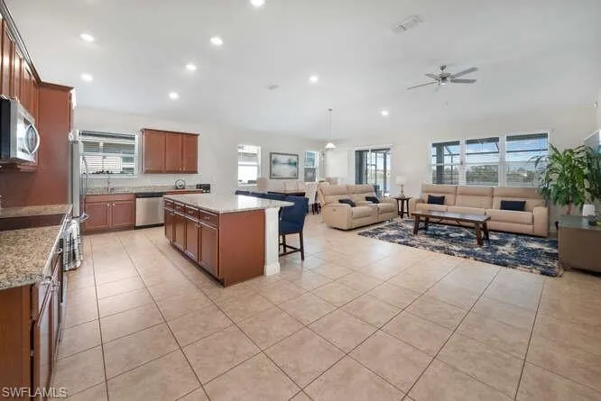 Kitchen featuring open floor plan, a center island, healthy amount of natural light, a breakfast bar area, and recessed lighting