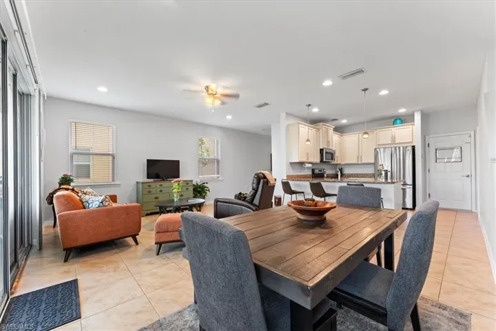 Dining area featuring light tile patterned floors, ceiling fan, and recessed lighting