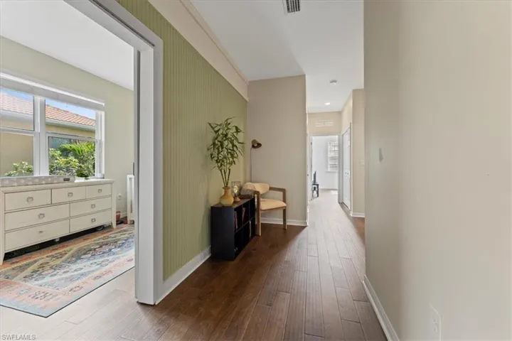 Corridor with dark wood-style floors and baseboards