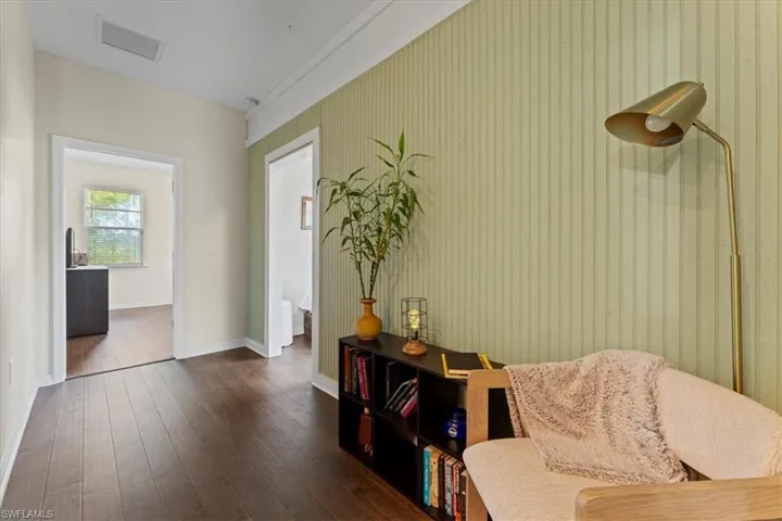 Living area with dark wood-type flooring and baseboards