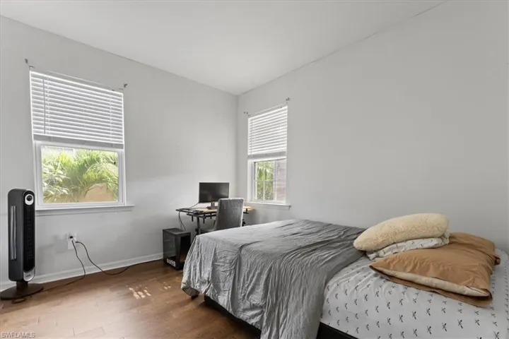 Bedroom with wood finished floors and baseboards