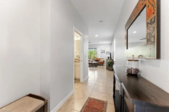 Hallway with recessed lighting, light tile patterned floors, and baseboards