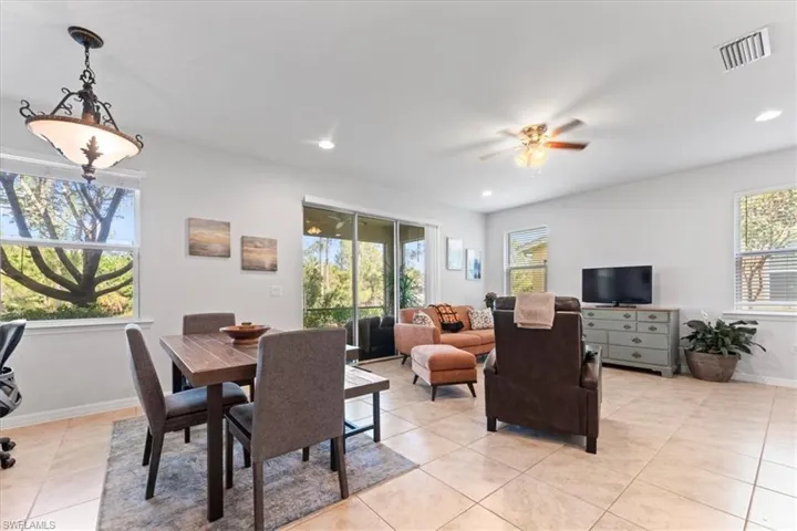 Dining room with light tile patterned flooring, ceiling fan, baseboards, and recessed lighting