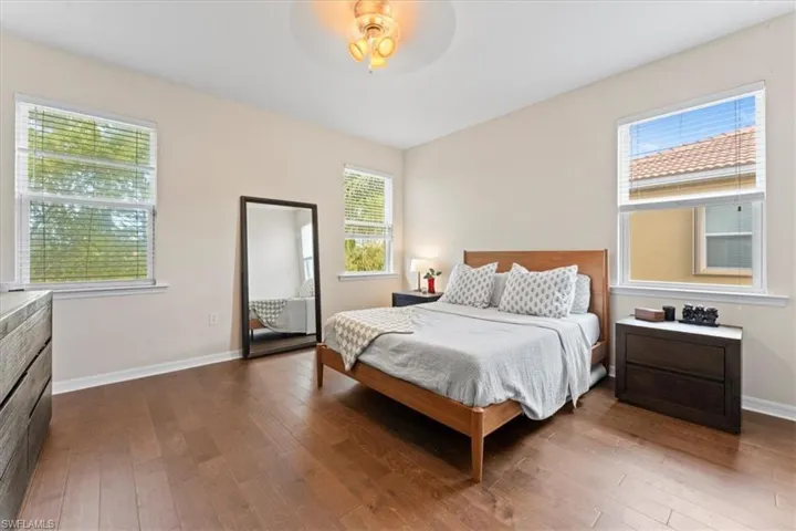 Bedroom featuring hardwood / wood-style flooring, baseboards, and a ceiling fan