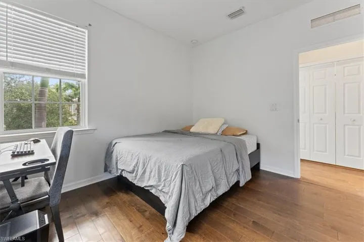Bedroom with hardwood / wood-style flooring and baseboards
