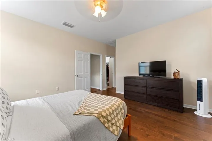 Bedroom with wood finished floors, baseboards, and a ceiling fan