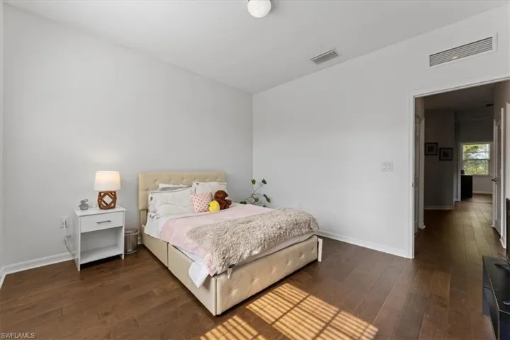 Bedroom with hardwood / wood-style floors and baseboards