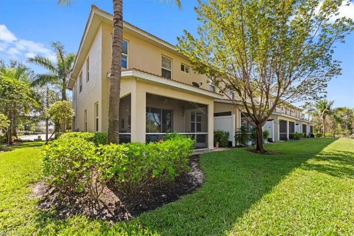 Back of house with stucco siding, a yard, and a sunroom