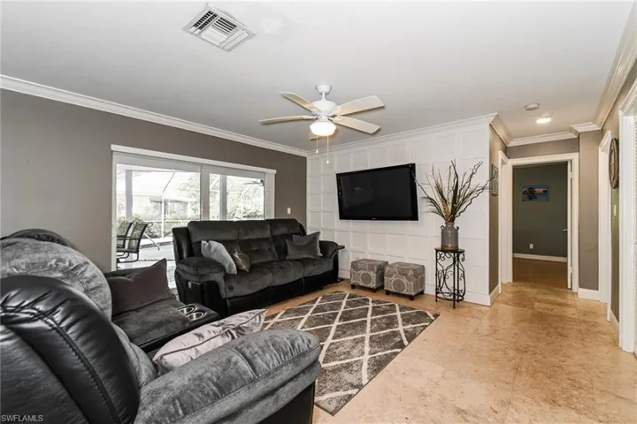 Living room featuring crown molding and ceiling fan