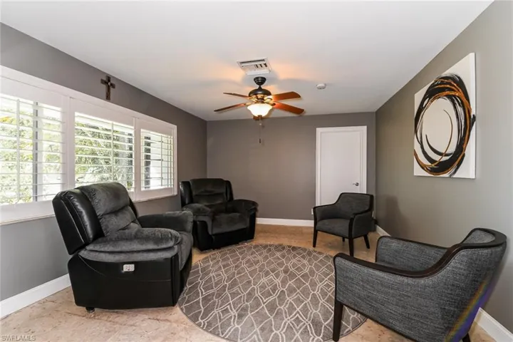 Living room with baseboards and a ceiling fan
