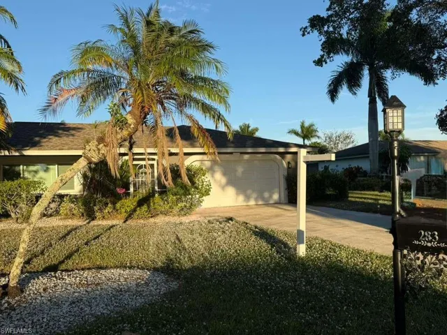 Ranch-style house featuring a garage, driveway, and stucco siding