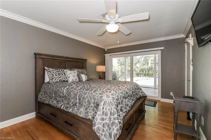 Bedroom with a textured wall, access to outside, light wood finished floors, ornamental molding, and a ceiling fan