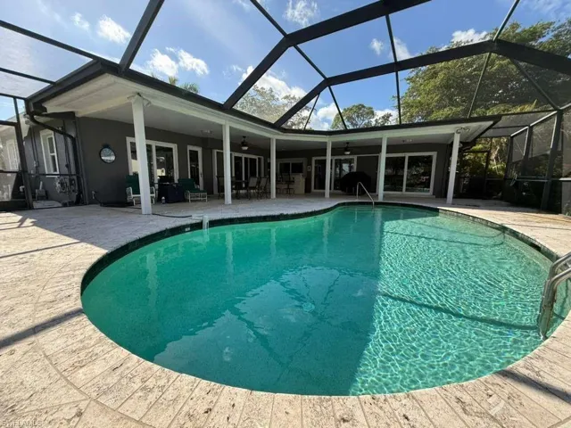 Swimming pool with a lanai, a sunroom, and a patio
