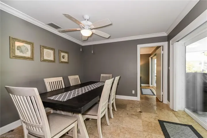 Dining space with ornamental molding and ceiling fan