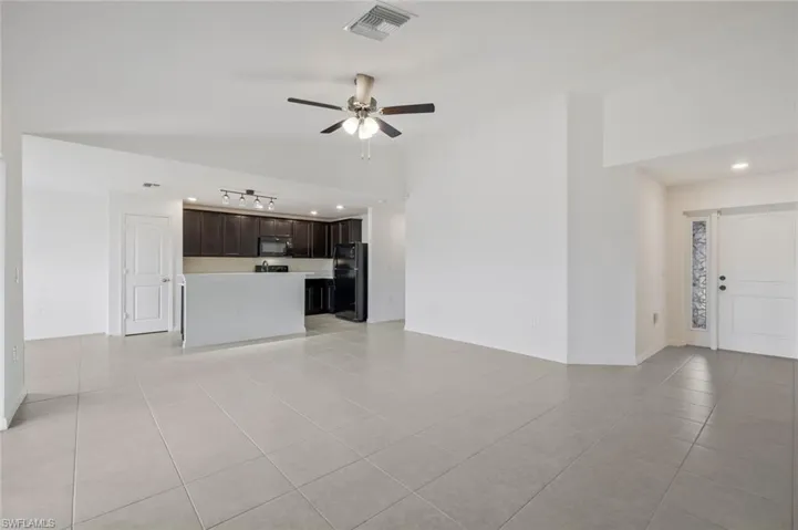 Unfurnished living room with ceiling fan, light tile patterned flooring, lofted ceiling, and recessed lighting
