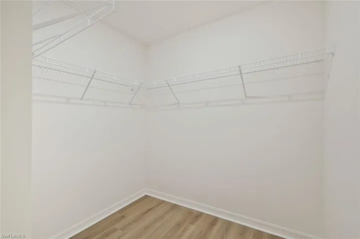 Walk in closet with light wood-style floors