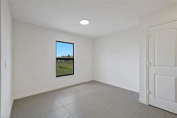 Unfurnished room with baseboards and light tile patterned flooring