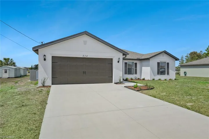 Single story home with a front lawn, a garage, stucco siding, and concrete driveway