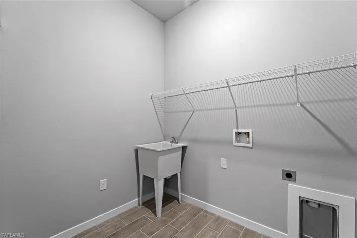 Laundry room with hookup for a washing machine, hookup for an electric dryer, and hardwood / wood-style flooring