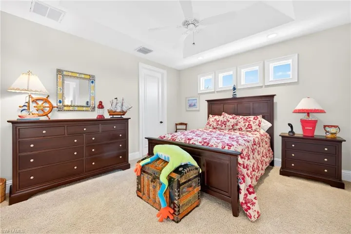 Bedroom featuring light carpet, a ceiling fan, a raised ceiling, and recessed lighting