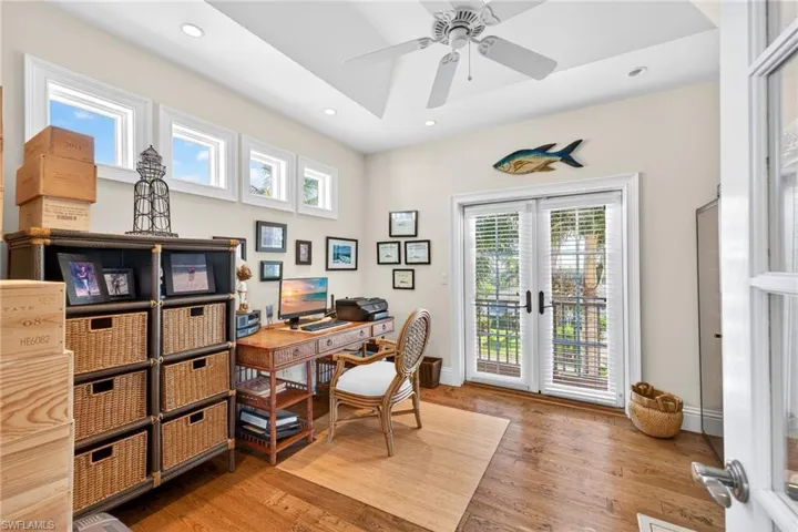Office space featuring plenty of natural light, french doors, a ceiling fan, light wood finished floors, and recessed lighting