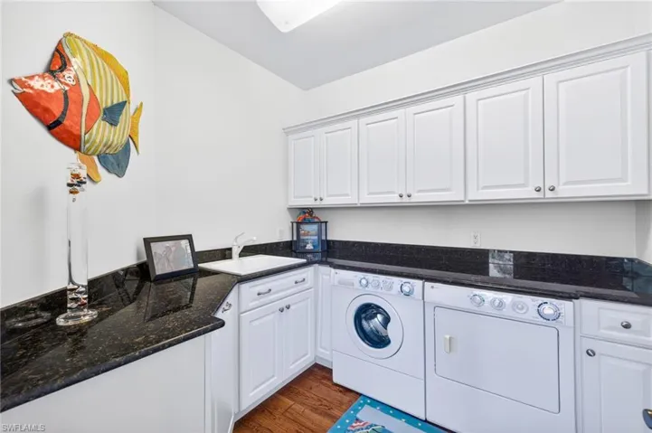 Washroom featuring cabinet space, dark wood-style flooring, and independent washer and dryer