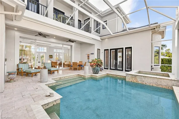 Outdoor pool with french doors, a patio area, a sunroom, and an outdoor living space