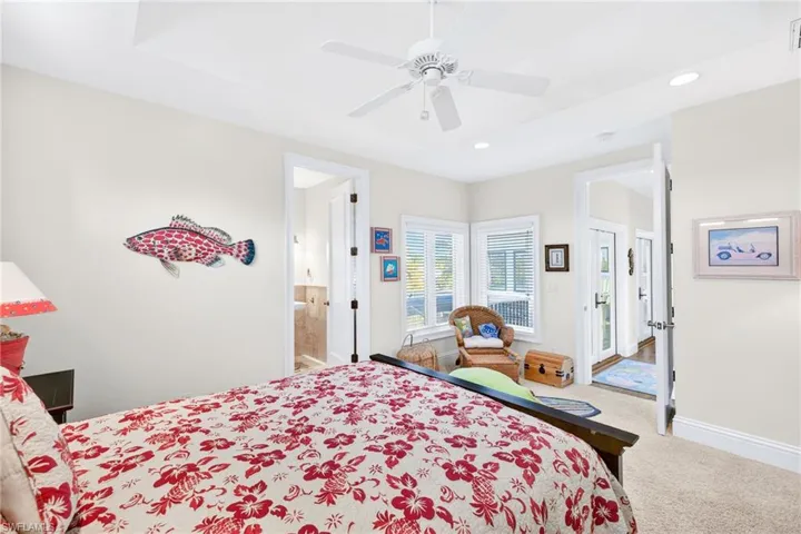 Carpeted bedroom with ceiling fan, recessed lighting, and ensuite bathroom