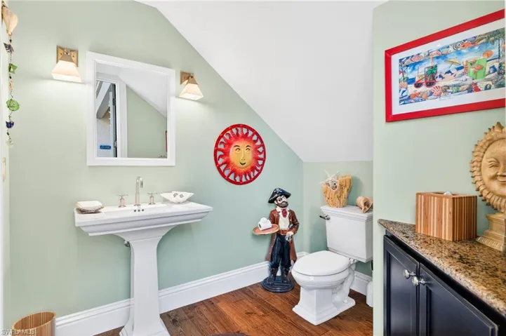 Pool bathroom with dark wood-style floors and lofted ceiling