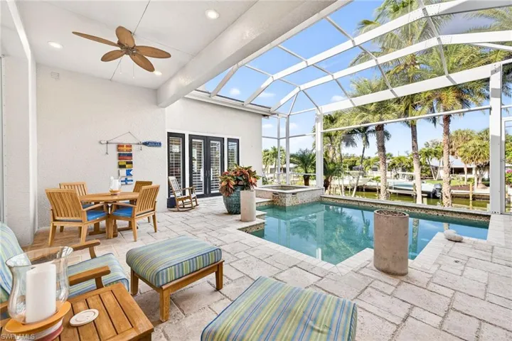 View of swimming pool with a lanai, a sunroom, a patio area, a pool with connected hot tub, and outdoor dining area