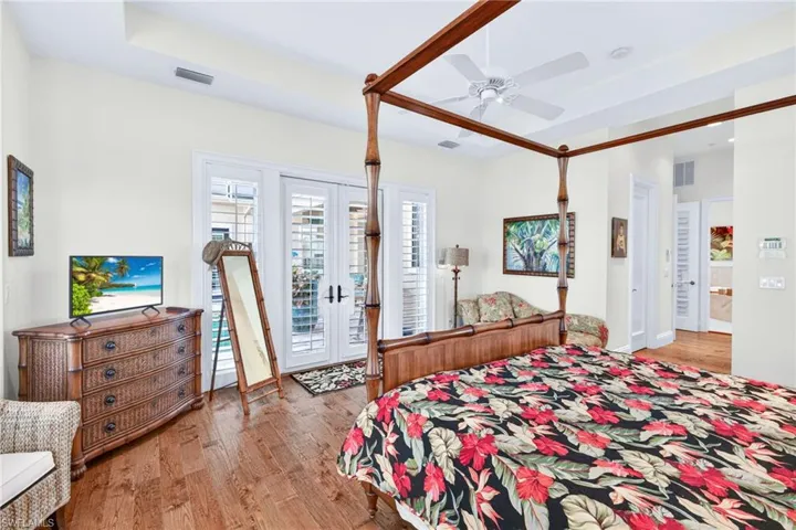 Bedroom with french doors, light wood-style floors, access to exterior, and a ceiling fan