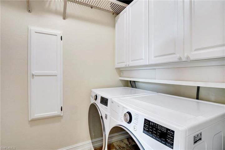 Inside laundry room with cabinetry and shelving.