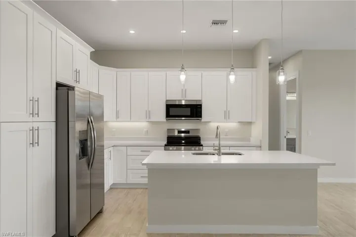 Gourmet kitchen with quartz island, shaker cabinets, and premium luxury vinyl plank (LVP) flooring upgrade.