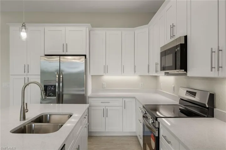 Gourmet kitchen with quartz island, shaker cabinets, and premium luxury vinyl plank (LVP) flooring upgrade.