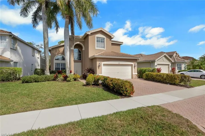 View of front facade with decorative driveway, stucco siding, a front lawn, an attached garage, and a tile roof