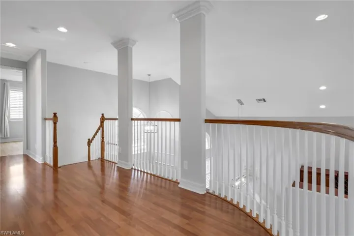 Hall featuring recessed lighting, an upstairs landing, and wood finished floors