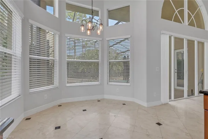 Unfurnished dining area with hanging lights and a high ceiling