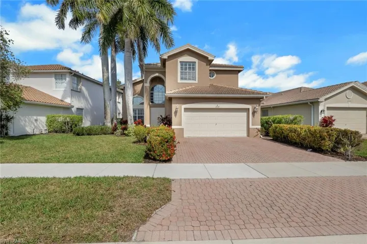 Mediterranean / spanish house featuring stucco siding, decorative driveway, a front yard, an attached garage, and a tile roof