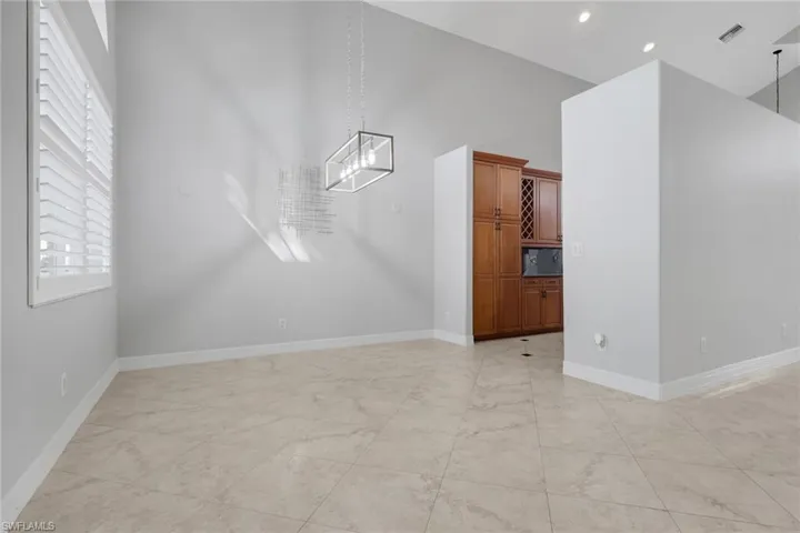 Unfurnished dining area featuring a high ceiling and a chandelier