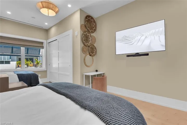Bedroom featuring baseboards, recessed lighting, wood finished floors, and a closet