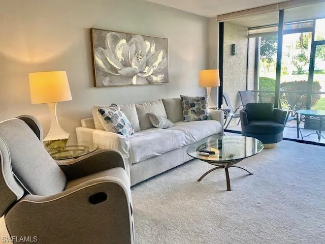 Living area featuring floor to ceiling windows and carpet