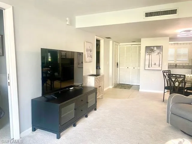 Living area featuring light carpet, baseboards, and visible vents