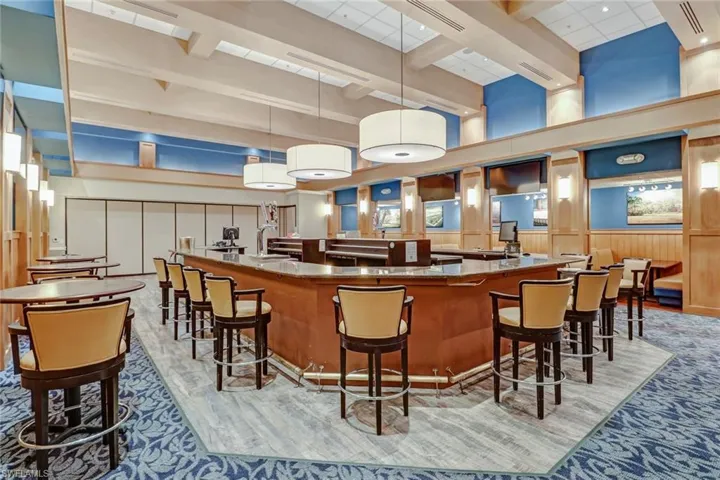 Bar with visible vents, beam ceiling, a towering ceiling, pendant lighting, and light carpet