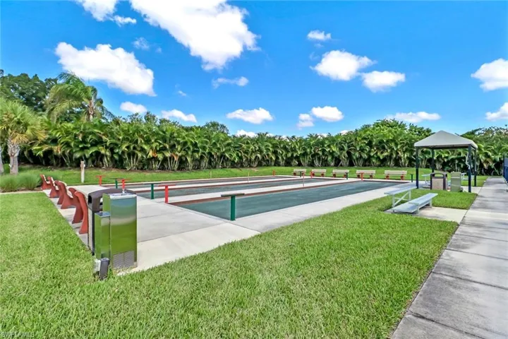 View of community with a yard and shuffleboard