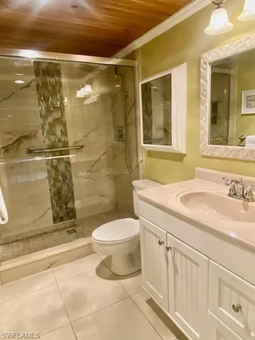Full bath with vanity, tile patterned flooring, crown molding, toilet, and wood ceiling